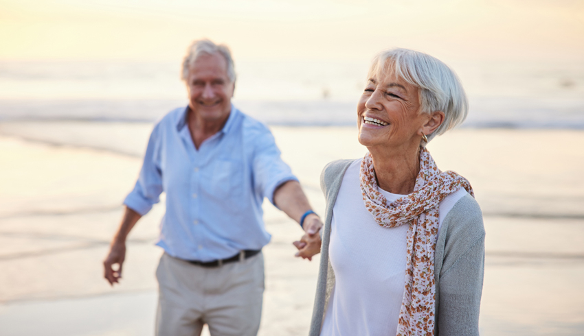 A mature couple walking on the beach